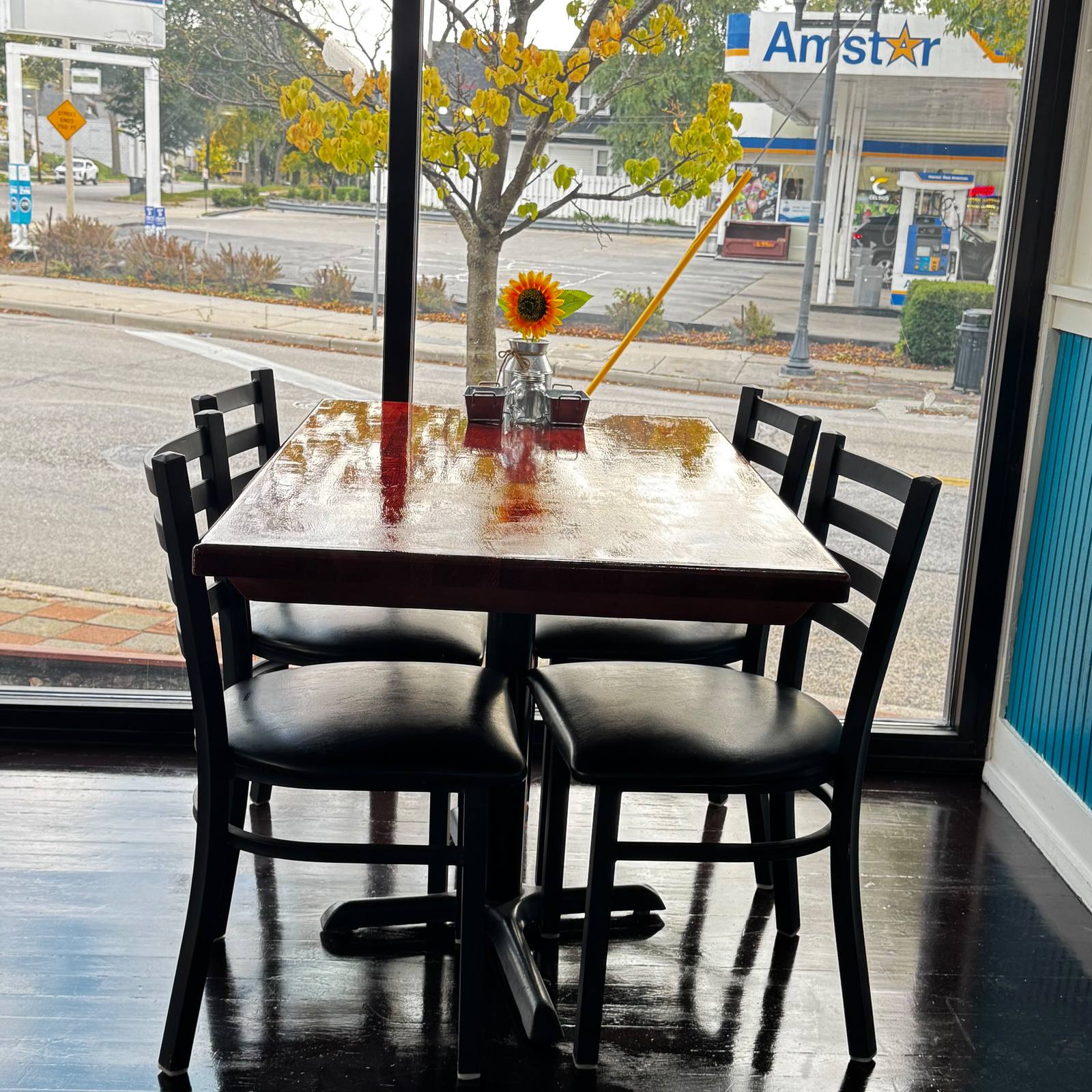 Table for four by the front window with a sunflower